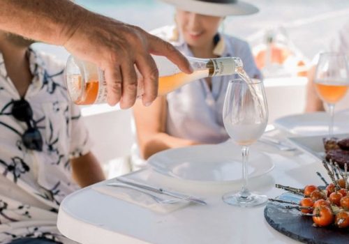 Serving wine during a private catamaran charter in Cancun
